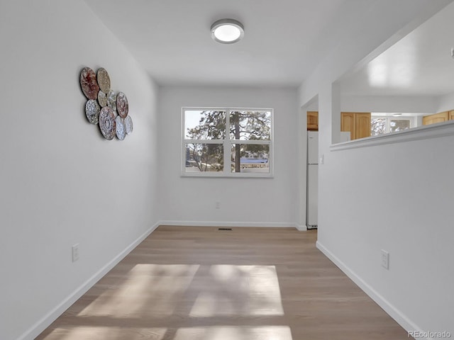 empty room with light hardwood / wood-style flooring and plenty of natural light