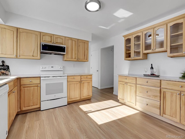 kitchen with light brown cabinets, white appliances, and light hardwood / wood-style flooring