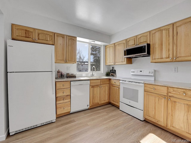 kitchen with sink, light brown cabinets, white appliances, and light hardwood / wood-style flooring