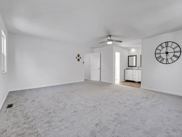 unfurnished living room with ceiling fan and light colored carpet