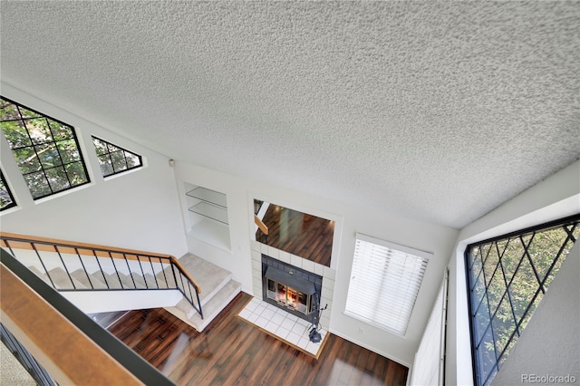 4802 E Kentucky Ave Unit E, Denver, CO 80246 - unfurnished living room featuring a textured ceiling, stairs, wood finished floors, and a fireplace