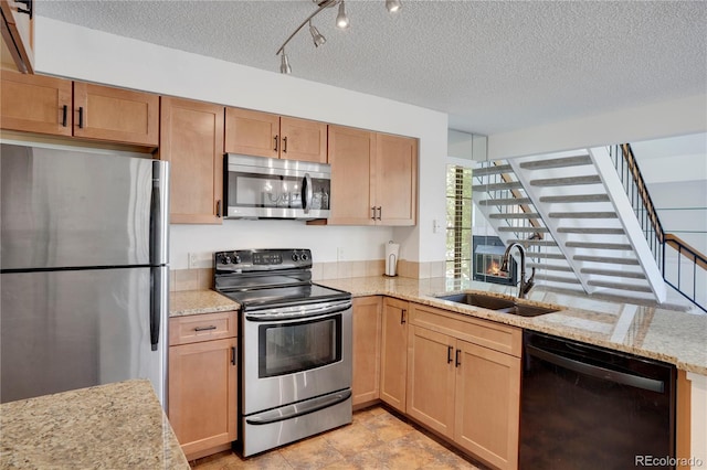 4802 E Kentucky Ave Unit E, Denver, CO 80246 - kitchen with stainless steel appliances, a sink, a textured ceiling, light stone countertops, and a peninsula