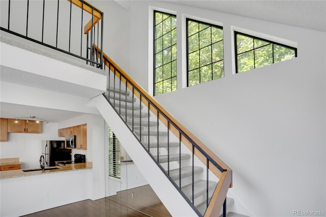 4802 E Kentucky Ave Unit E, Denver, CO 80246 - stairs with plenty of natural light, wood finished floors, and a high ceiling