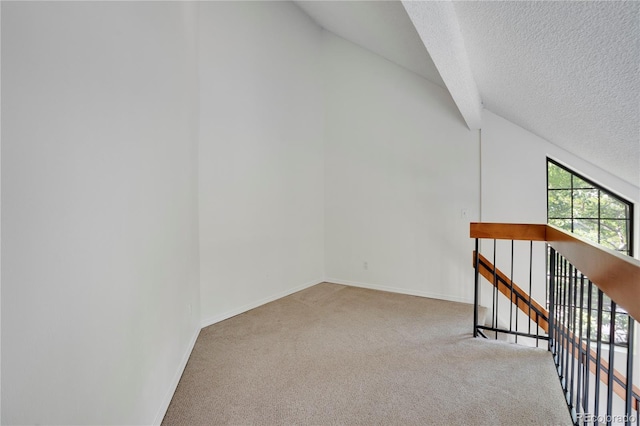 4802 E Kentucky Ave Unit E, Denver, CO 80246 - hall featuring carpet floors, lofted ceiling, a textured ceiling, baseboards, and an upstairs landing