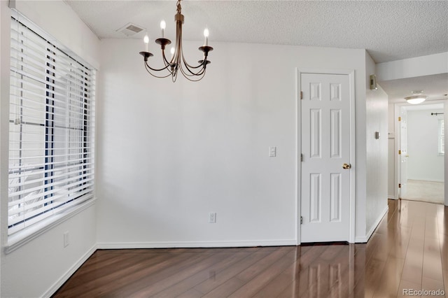 4802 E Kentucky Ave Unit E, Denver, CO 80246 - unfurnished dining area with a chandelier, wood finished floors, a textured ceiling, and plenty of natural light