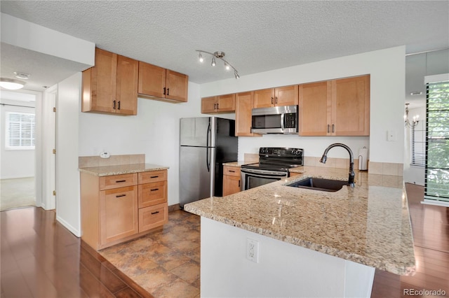 4802 E Kentucky Ave Unit E, Denver, CO 80246 - kitchen with appliances with stainless steel finishes, a sink, a peninsula, light stone counters, and a textured ceiling