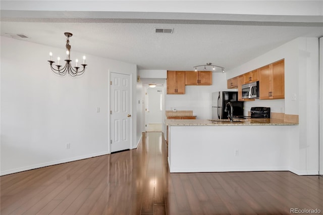 4802 E Kentucky Ave Unit E, Denver, CO 80246 - kitchen with stainless steel microwave, freestanding refrigerator, a peninsula, electric range, and a chandelier