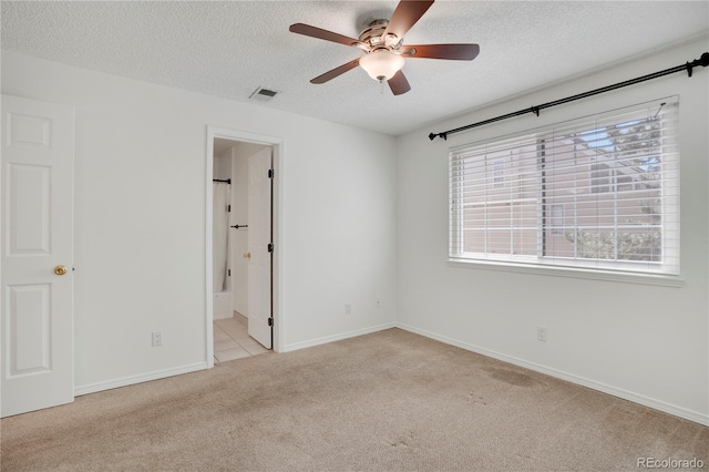4802 E Kentucky Ave Unit E, Denver, CO 80246 - unfurnished bedroom with a textured ceiling, light colored carpet, multiple windows, baseboards, and ensuite bathroom