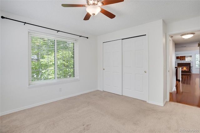 4802 E Kentucky Ave Unit E, Denver, CO 80246 - unfurnished bedroom featuring carpet flooring, multiple windows, a closet, baseboards, and a textured ceiling