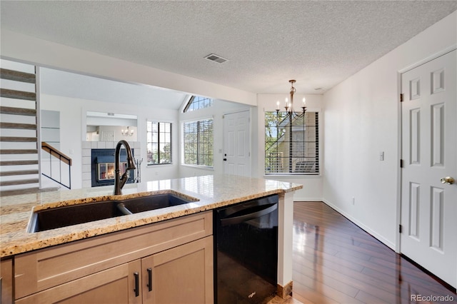 4802 E Kentucky Ave Unit E, Denver, CO 80246 - kitchen with black dishwasher, a sink, a chandelier, dark wood-style floors, and a tiled fireplace
