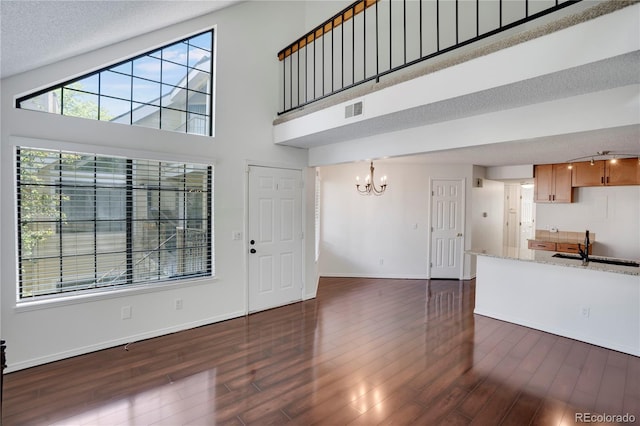 4802 E Kentucky Ave Unit E, Denver, CO 80246 - unfurnished living room with a chandelier, dark wood-type flooring, healthy amount of natural light, and a textured ceiling