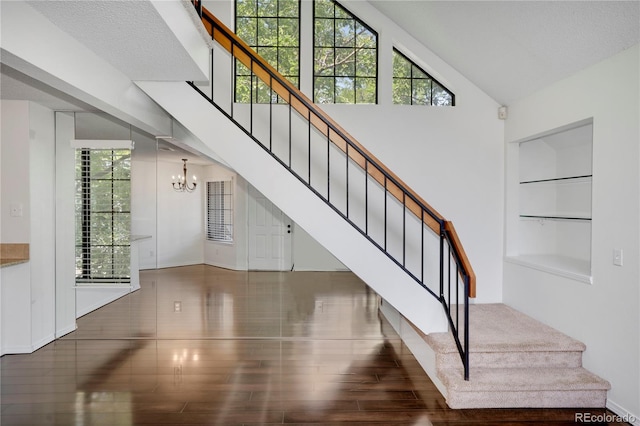 4802 E Kentucky Ave Unit E, Denver, CO 80246 - staircase with a chandelier, built in shelves, plenty of natural light, wood finished floors, and a towering ceiling
