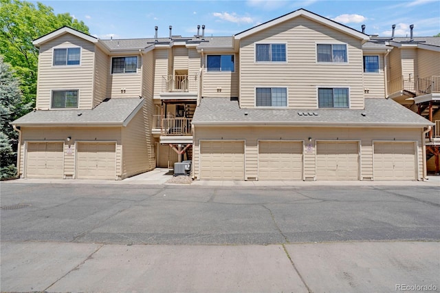 4802 E Kentucky Ave Unit E, Denver, CO 80246 - view of property featuring central air condition unit, a garage, and a balcony