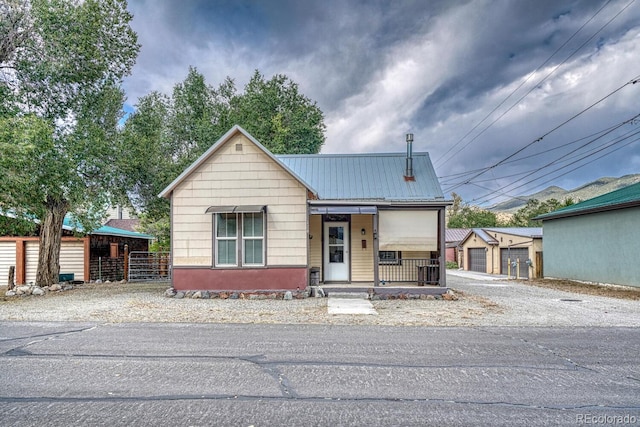 124 E 8th St, Salida, CO 81201 - view of front facade featuring covered porch, fence, an outdoor structure, and metal roof