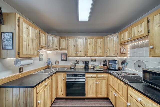 124 E 8th St, Salida, CO 81201 - kitchen with black oven, light brown cabinets, dark countertops, a sink, and backsplash