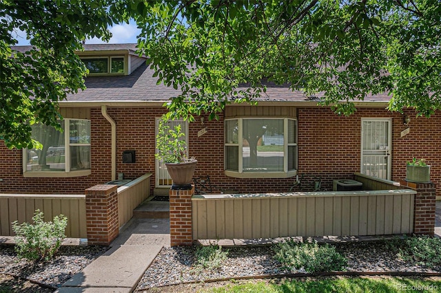 3300 W Florida Ave Unit 51, Denver, CO 80219 - view of front facade featuring a shingled roof and brick siding