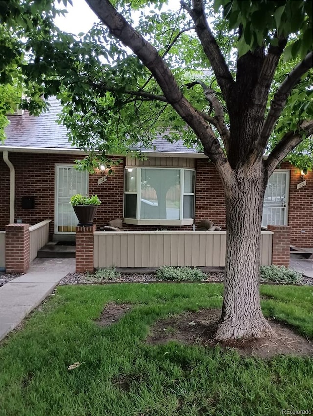 3300 W Florida Ave Unit 51, Denver, CO 80219 - view of front facade featuring brick siding and a shingled roof