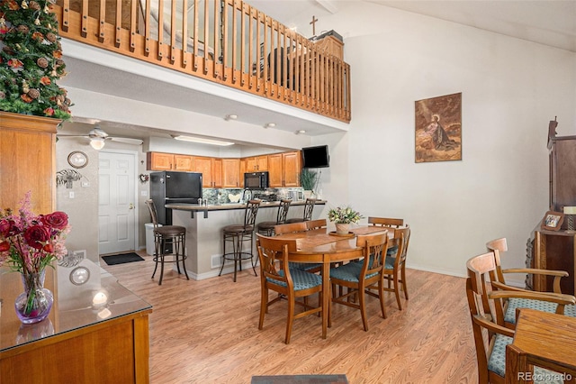3300 W Florida Ave Unit 51, Denver, CO 80219 - dining area with light wood-style floors, a ceiling fan, baseboards, and high vaulted ceiling