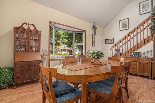 3300 W Florida Ave Unit 51, Denver, CO 80219 - dining room featuring light wood-style floors, stairs, and high vaulted ceiling