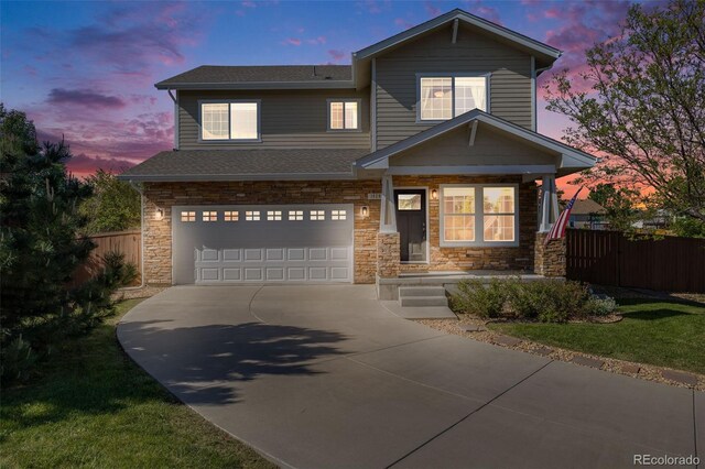 19294 E Warren Pl, Aurora, CO 80013 - view of front facade with a garage, concrete driveway, stone siding, a shingled roof, and covered porch