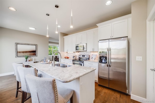19294 E Warren Pl, Aurora, CO 80013 - kitchen with stainless steel appliances, a center island with sink, a sink, decorative backsplash, and white cabinetry