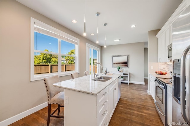 19294 E Warren Pl, Aurora, CO 80013 - kitchen featuring a sink, stainless steel appliances, baseboards, white cabinetry, and dark wood finished floors