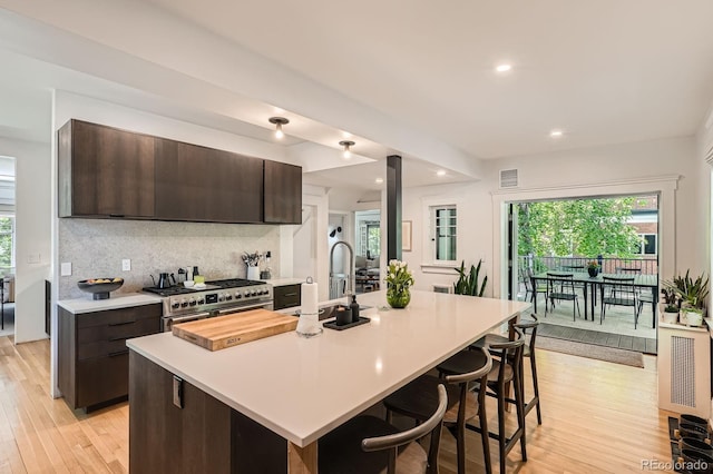 785 Fillmore St, Denver, CO 80206 - kitchen with light countertops, a sink, high end stainless steel range, dark brown cabinetry, and recessed lighting