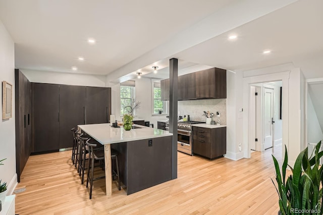 785 Fillmore St, Denver, CO 80206 - kitchen with high end stainless steel range oven, light countertops, dark brown cabinetry, modern cabinets, and recessed lighting