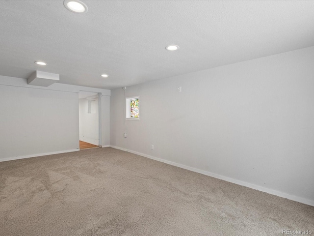 spare room with recessed lighting, carpet flooring, a textured ceiling, and baseboards