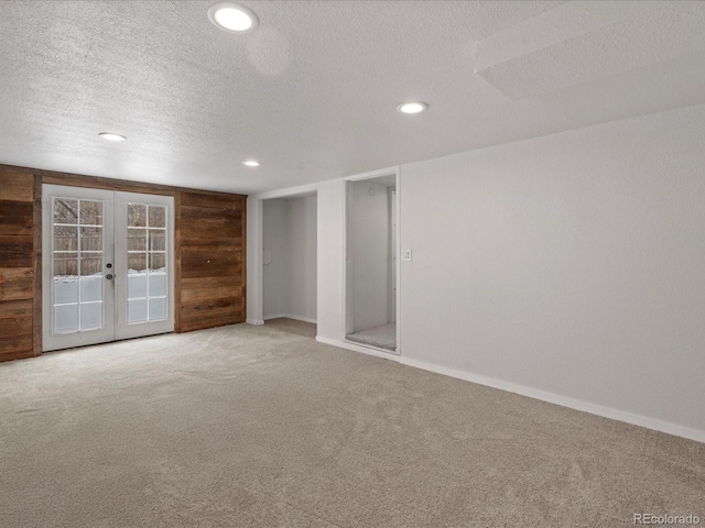 carpeted spare room featuring a textured ceiling, french doors, recessed lighting, and baseboards