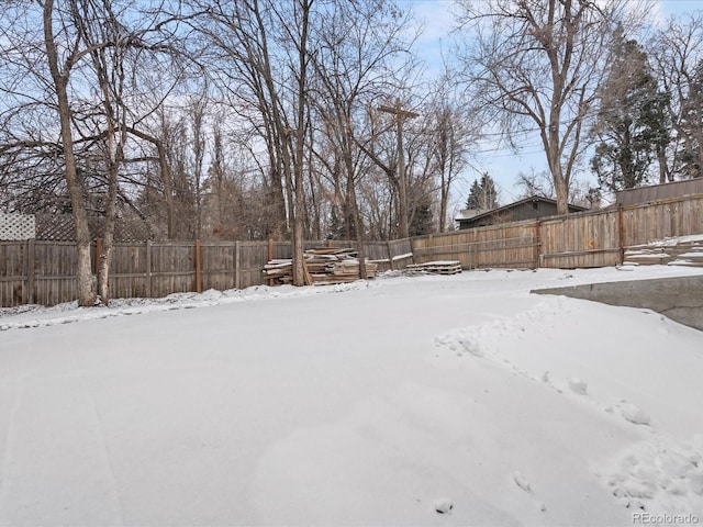 yard covered in snow with a fenced backyard