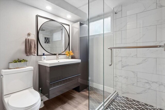 5185 N Meade St, Denver, CO 80221 - full bath featuring toilet, a shower stall, vanity, wood finished floors, and recessed lighting