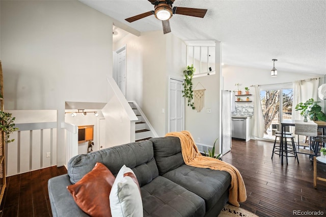 living room featuring a textured ceiling, dark wood-type flooring, ceiling fan, and lofted ceiling