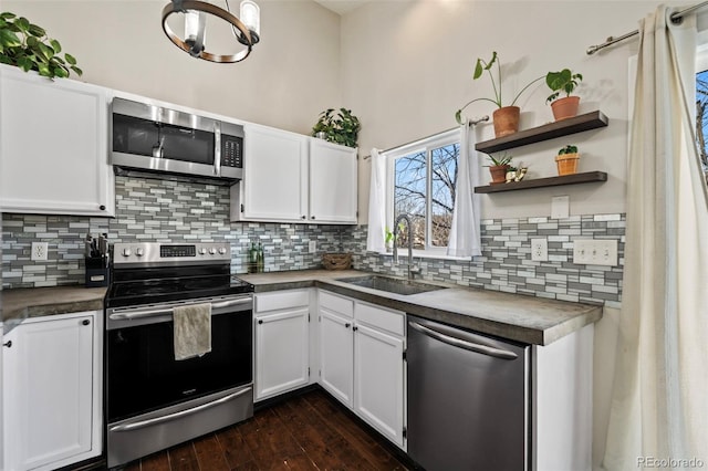 kitchen featuring dark wood-type flooring, an inviting chandelier, sink, white cabinetry, and stainless steel appliances