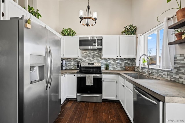 kitchen featuring sink, stainless steel appliances, a chandelier, pendant lighting, and white cabinets