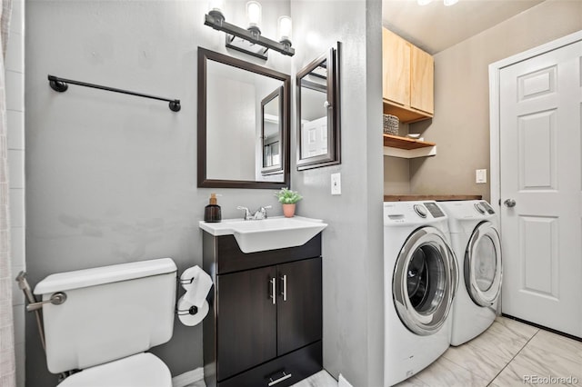 clothes washing area featuring washer and clothes dryer and sink