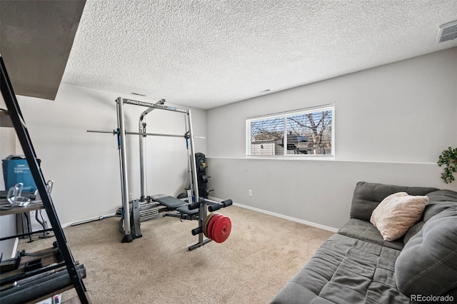 exercise area with a textured ceiling and light colored carpet