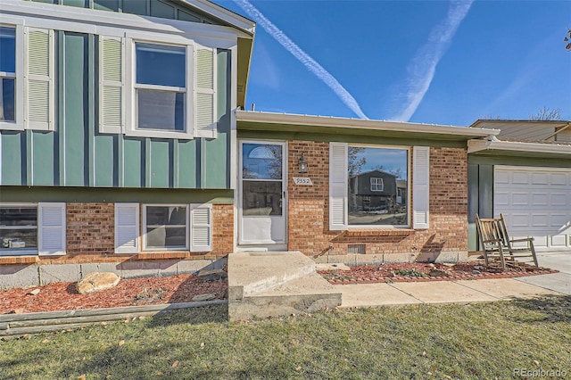 property entrance with a garage and a lawn