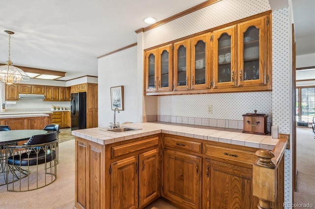 kitchen with black fridge with ice dispenser, a sink, ornamental molding, ventilation hood, and wallpapered walls