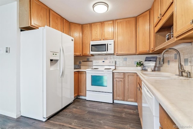 kitchen with dark wood-style floors, white appliances, light countertops, and a sink