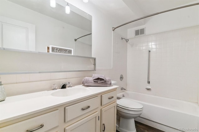 full bathroom featuring vanity, visible vents,  shower combination, tile walls, and toilet