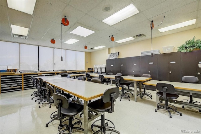 office area with visible vents, light floors, and a paneled ceiling