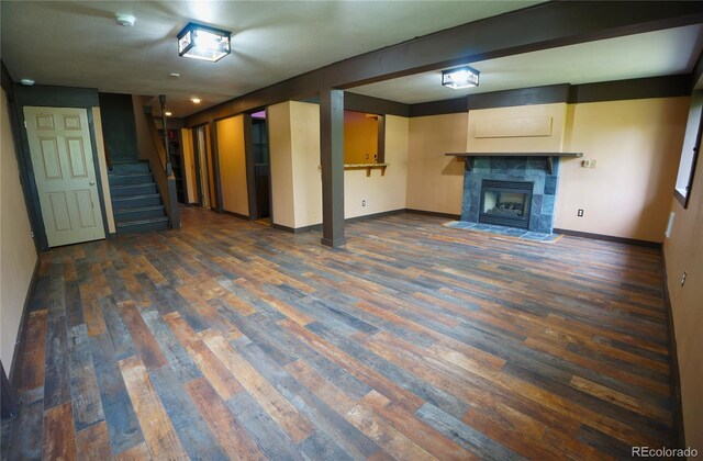 116 Timber Rd, Black Hawk, CO 80422 - unfurnished living room with dark wood-type flooring, stairway, and a tile fireplace
