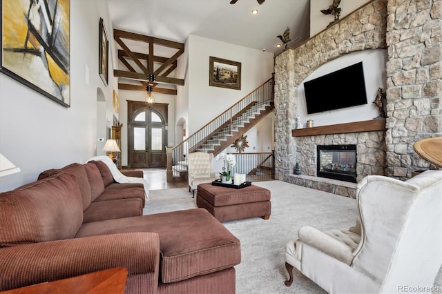 carpeted living room featuring high vaulted ceiling, ceiling fan, and a fireplace