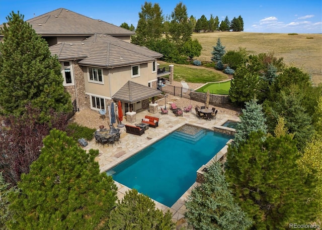 view of swimming pool featuring an in ground hot tub, a patio area, an outdoor fire pit, and a yard