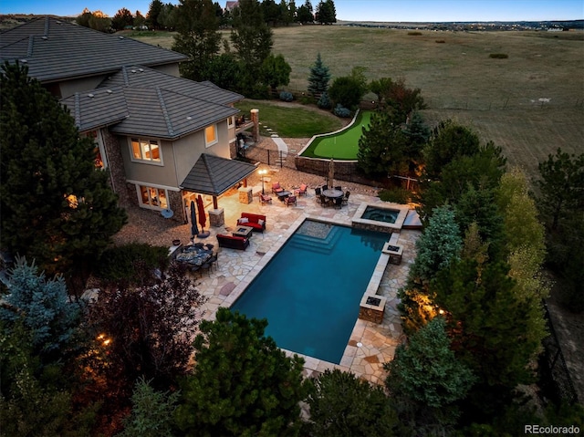 view of swimming pool with an outdoor fire pit, a lawn, an in ground hot tub, and a patio area