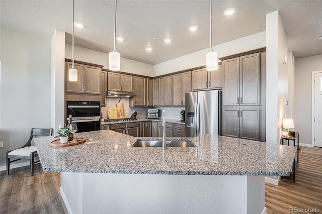 811 W 128th Pl, Westminster, CO 80234 - kitchen with stainless steel appliances, under cabinet range hood, wood finished floors, light stone countertops, and recessed lighting