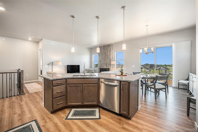 811 W 128th Pl, Westminster, CO 80234 - kitchen with dishwasher, light wood-style flooring, an island with sink, and light stone counters