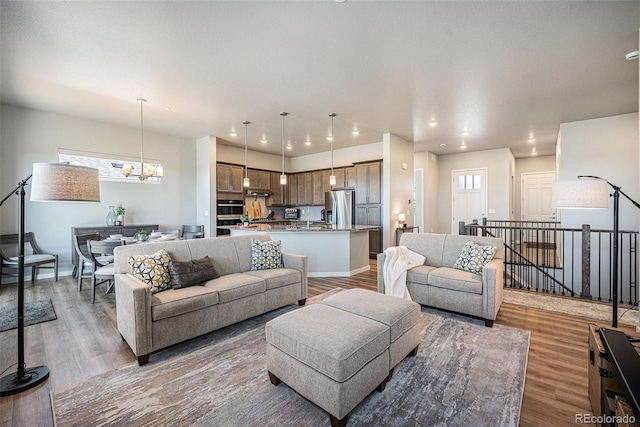 811 W 128th Pl, Westminster, CO 80234 - living room featuring light wood-type flooring, a chandelier, and recessed lighting