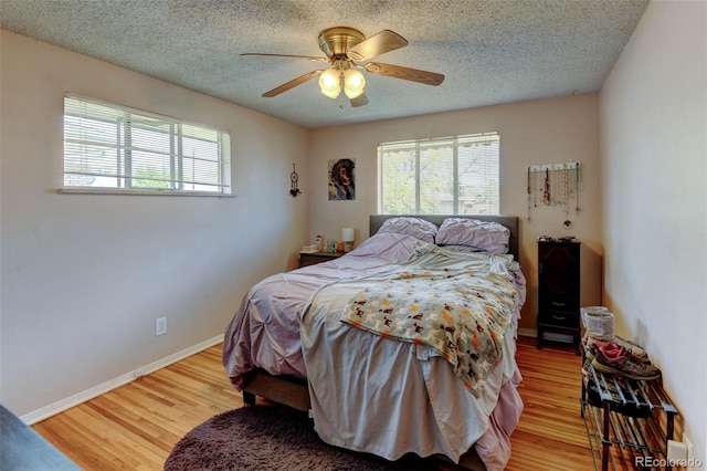 10560 W 63rd Ave, Arvada, CO 80004 - bedroom featuring multiple windows, wood finished floors, ceiling fan, and a textured ceiling